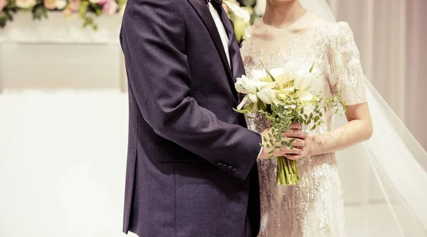 花嫁の結婚式の花束と結婚式の日に新郎の手 — ストック写真