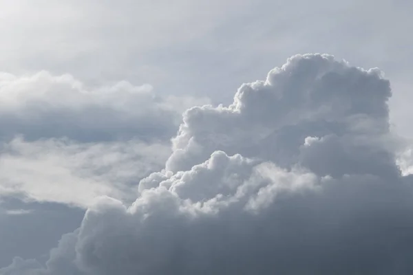 White curly clouds on a gentle blue sky.