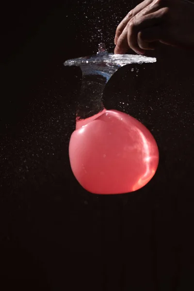 balloon filled with water is punctured and the exploding water t