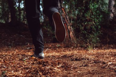 Çocuk sabah ormanda usulca koşuyor.
