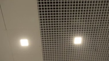 POV, hastane koridorundaki bir hastanın bakış açısı. Tavan ızgaraları ve klimalı paneller bölünmüş, neon ışıklar ve ekranlar