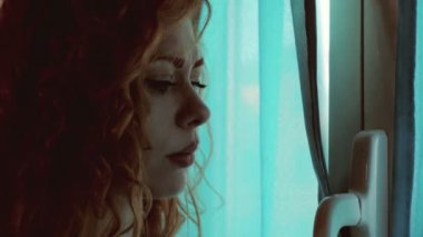 Dünyadan korkan depresif genç kadın pencereden dışarı çıkıp çıkmayacağına karar verememiş.