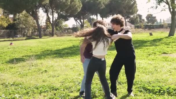 三个年轻人在公园里欢欢喜喜地互相欢呼拥抱的慢动作 — 图库视频影像