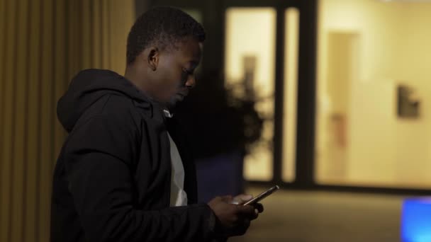 Porträt Eines Jungen Schwarzen Mannes Der Auf Sein Handy Tippt — Stockvideo