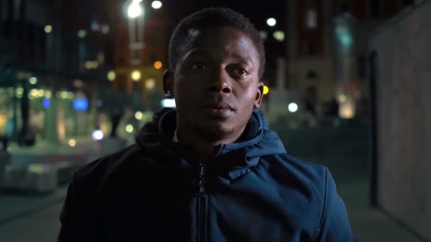 国と家族の郷愁に苦しむ夜の街の若い不幸な黒人の肖像画 — ストック動画