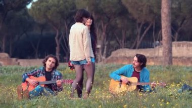 Parkta dans eden iki genç kadına ağır çekimde gitar çalan iki arkadaşları eşlik ediyor.