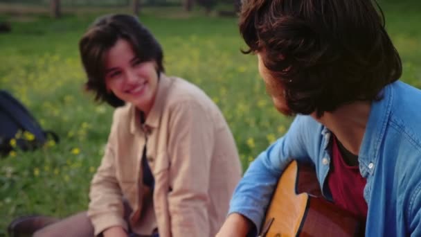 彼女のために公園でギターを弾いている若い男の肖像画 — ストック動画