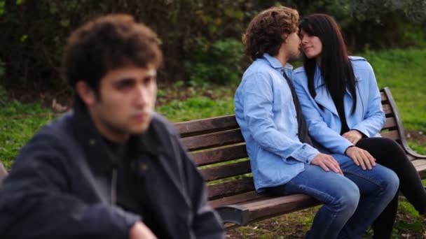 Młoda Para Miłości Całuje Się Ławce Parku Podczas Gdy Samotny — Wideo stockowe