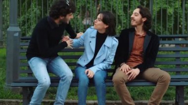 Genç adam, ortak bir arkadaşı geldiğinde onu sohbetin dışında tutan bir arkadaşıyla konuşur.