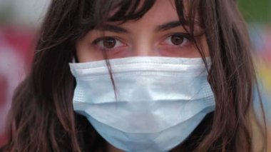 Kameraya ciddi ciddi bakan, maske takan güzel bir kadının portresini yakından çek.