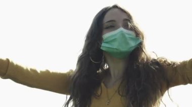 Covid 19 - Maske takarak dans eden güzel mutlu kız üzerinde ağır çekim