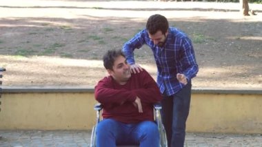 Destek, yardım - engelli bir arkadaşla genç adam şakalaşıyor