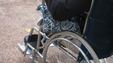 Rahat, yardım - Adam şehirde tekerlekli sandalyeyle kız arkadaşını itiyor.