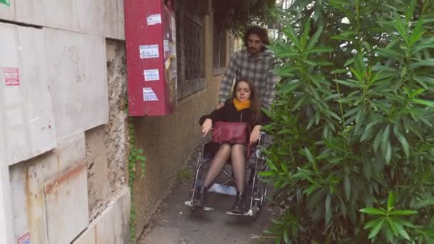 Pomoc Wsparcie Młody Mężczyzna Popycha Swoją Dziewczynę Pomocą Wózka Inwalidzkiego — Wideo stockowe