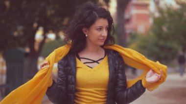 Güzel, baştan çıkaran kadın atkısını takar ve rüzgarlı bir günde kameraya bakar.