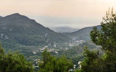 Bulutlu arazi ve aralarından geçen güneş.