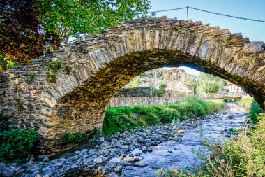 Az suyu ve taş köprüsü olan bir nehir.