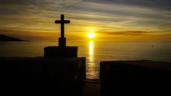 Günbatımında Turuncu Renklerde Bir Hıristiyan Haçının Arka Işığı — Stok fotoğraf