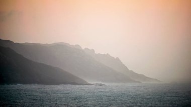 Galiçya kıyısındaki kayalıklarda turuncu gün batımı