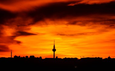 Madrid şehrinin panoramik manzarası gün batımında renkli bulutlarla gökyüzü.