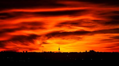 Madrid şehrinin panoramik manzarası gün batımında renkli bulutlarla gökyüzü.