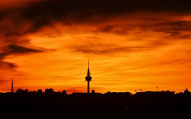 Madrid şehrinin panoramik manzarası gün batımında renkli bulutlarla gökyüzü.