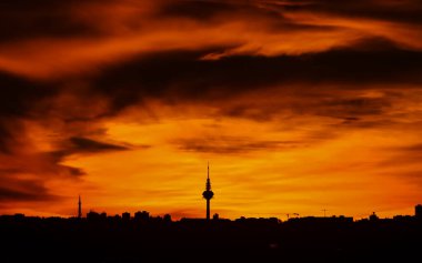Madrid şehrinin panoramik manzarası gün batımında renkli bulutlarla gökyüzü.