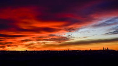 Madrid şehrinin panoramik manzarası gün batımında renkli bulutlarla gökyüzü.