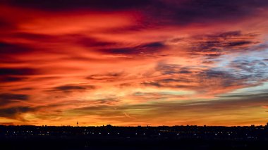 Madrid şehrinin panoramik manzarası gün batımında renkli bulutlarla gökyüzü.