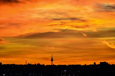 Madrid şehrinin panoramik manzarası gün batımında renkli bulutlarla gökyüzü.