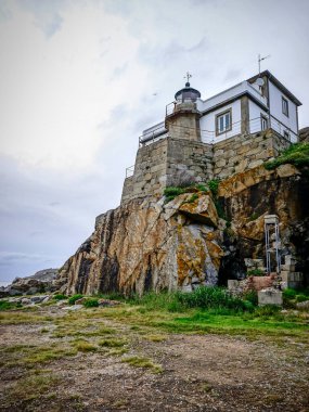 Bulutlu bir günde Galiçya sahilindeki deniz fenerinin panoramik manzarası