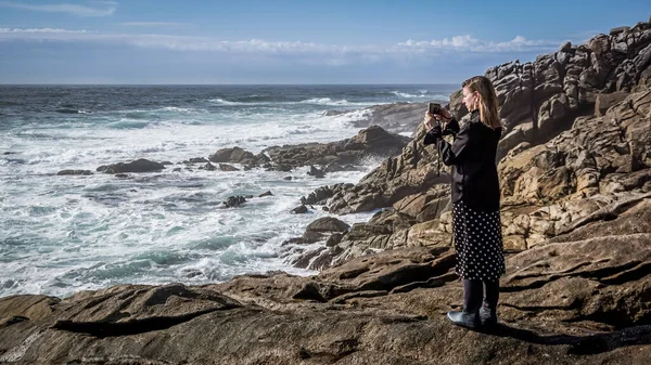 ガリツィアの海岸で携帯電話で写真を撮る若いと美しい女性 — ストック写真