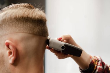 Bir kadının eli, bir erkeğin kafasını kesiyor.