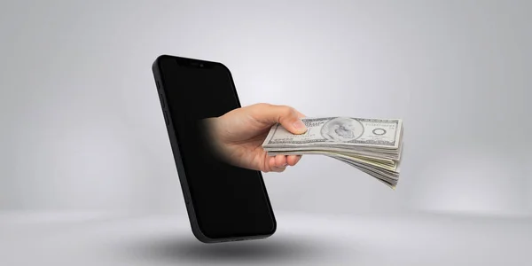 Make money on the Internet, hand holding money with smart mobile on grey background, finance, trading and loan concept