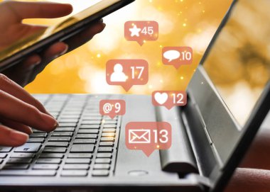 Sosyal medya simgeleriyle akıllı telefon ve dizüstü bilgisayarla çalışan iş kadınlarının kapatılması