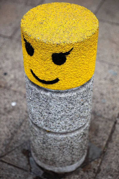 Gelb Und Grau Lackierter Poller Mit Smiley Gesicht Und Wimpern — Stockfoto