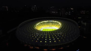 Night Football Stadium in Kyiv, Ukraine. The view from the top to the illuminated Olympic stadium with games and fans. High quality 4k footage