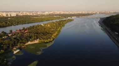 Ukrayna 'nın başkenti Kiev' deki Trukhaniv adasının üzerinden güzel bir uçuş. Park ve ağaç yeşil yapraklarla taçlandırıldı, Dnipro nehri. Yüksek kalite 4k görüntü