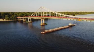 Ukrayna 'nın başkenti Kyiv' deki Dnipro nehri üzerindeki yaya köprüsünün hava görüntüsü. Sinema robotu görüntüsü 4K. Yüksek kalite 4k görüntü