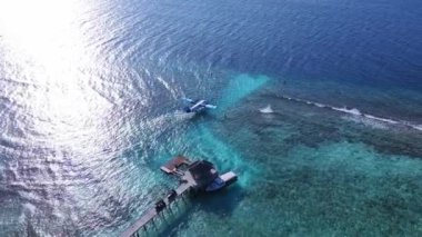 Seaplane on the runway, get ready to take off. Tropical atoll island in Maldives with coral reef and turquoise sea water. Touristic vacation holidays travel destination. Scenic seascape. Vakkaru