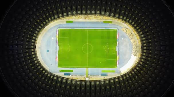 Descending Top Down view of Night Football Stadium in Kyiv, Ukraine. Drone perspective on illuminated Olympic stadium with soccer game and fans. High quality 4k footage