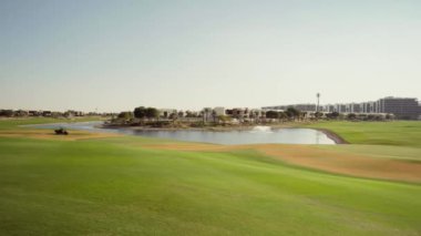Dubai 'deki Trump Golf Kulübü. Golf parkı manzarasında çayır çimenleri ve evler. Dünyanın en iyi golf sopaları. Yüksek kalite 4k görüntü