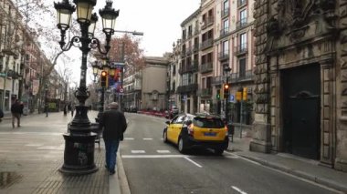 Barselona, Katalonya, İspanya - Aralık 2021: taksi kırmızı ışıkta durdu, Yaşlı adam Barcelona 'da yürüdü.