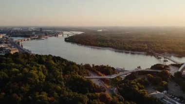 Dnipro Nehri, yaya köprüsü ve güzel Gündoğumu 'nda Ukrayna halkının Özgürlük Kemeri. Kyiv, Ukrayna. Sinematik İHA görüntüleri. 4k Yüksek Kalite