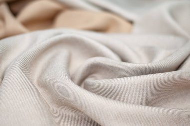Kıyafet ve yatak ipleri için doğal pamuk kumaş. Bükülmüş kumaş arka planı. Yakın çekim.
