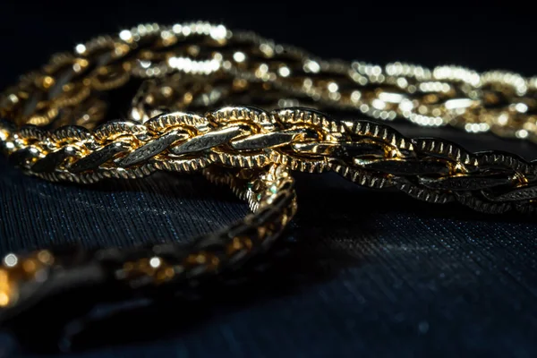 gold necklace, precious item, gold on a black background