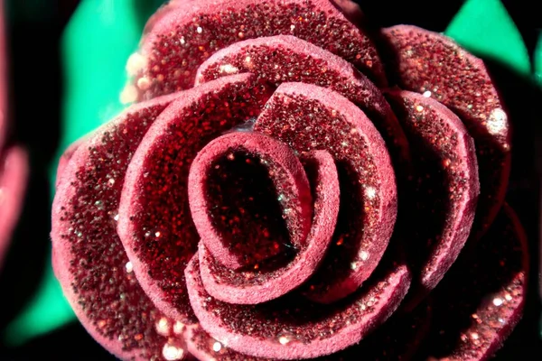 composition artificial rose with sparkles on a black background