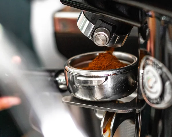 Coffee is made in a coffee machine. Barista preparing espresso in cafe.
