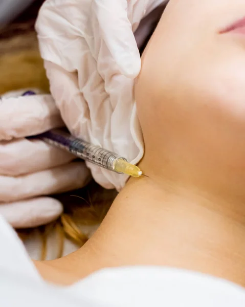 Injection into the neck. Procedure for beauty and health. Cosmetology clinic. The doctor gives an injection.