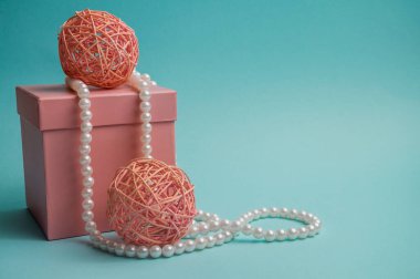 Pink gift box and wicker balls on a blue background. Subject photo.